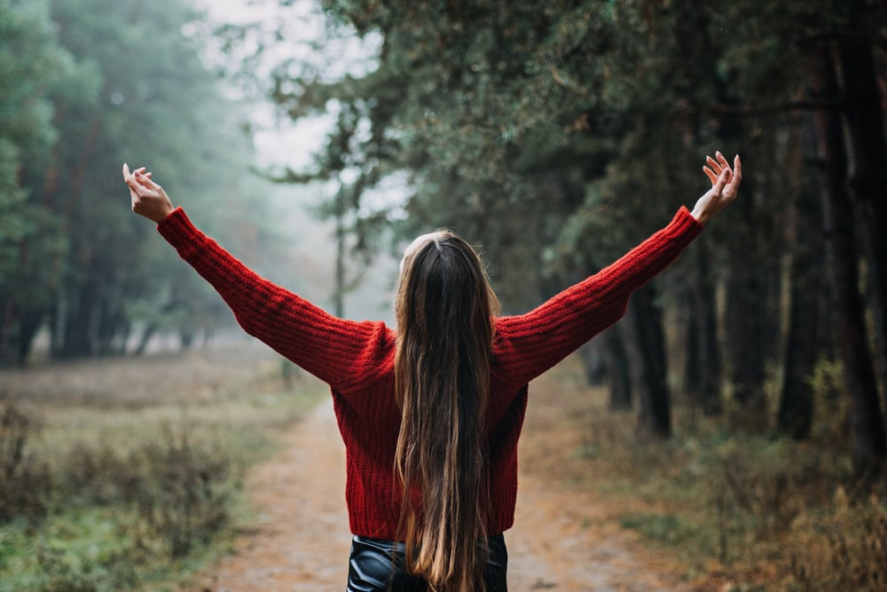 Alone Young woman with long fluttering hair express emotions in forest